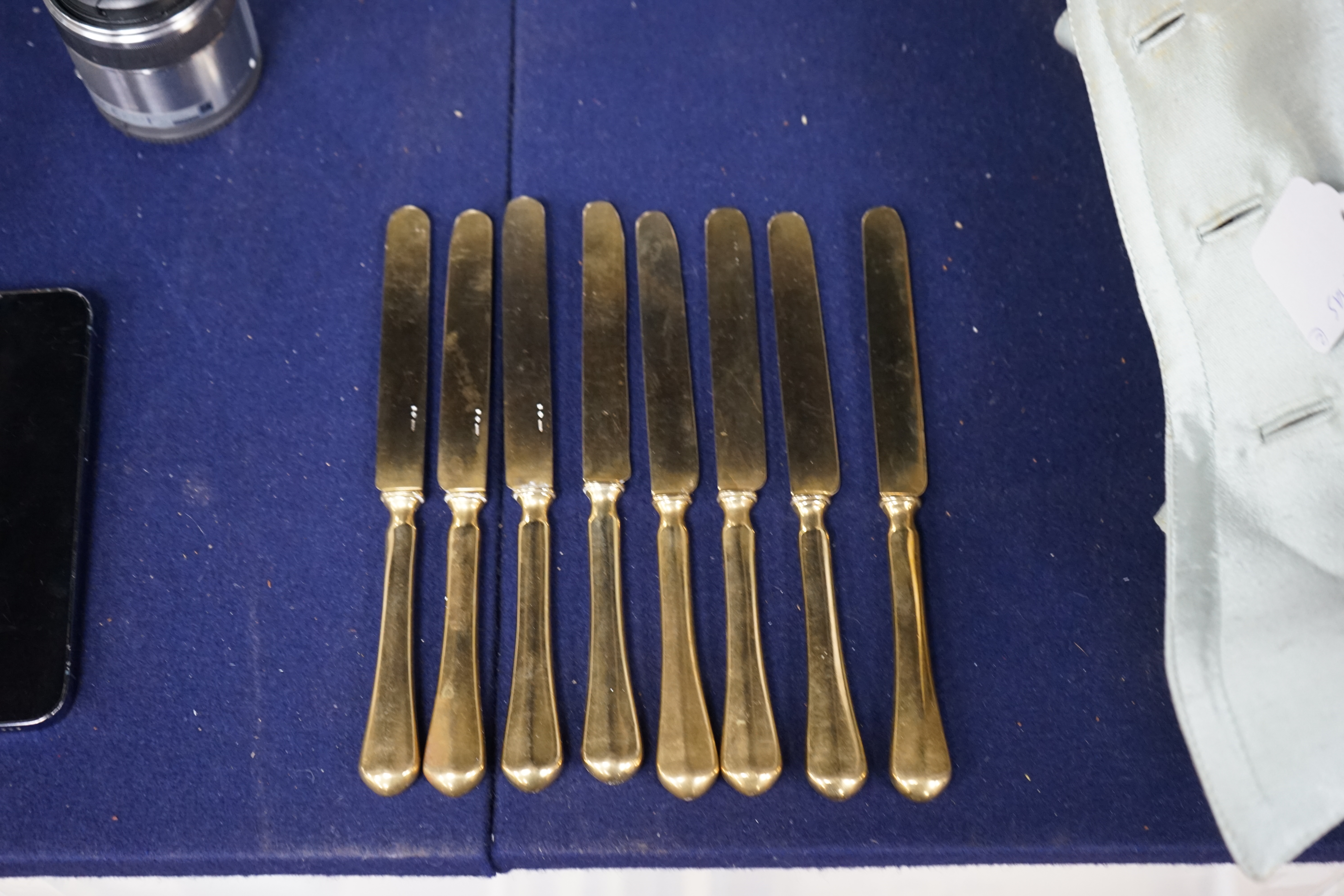 A set of eight French gilt plated dessert knives, 20cm. Condition- fair to good, some nicks and scratches